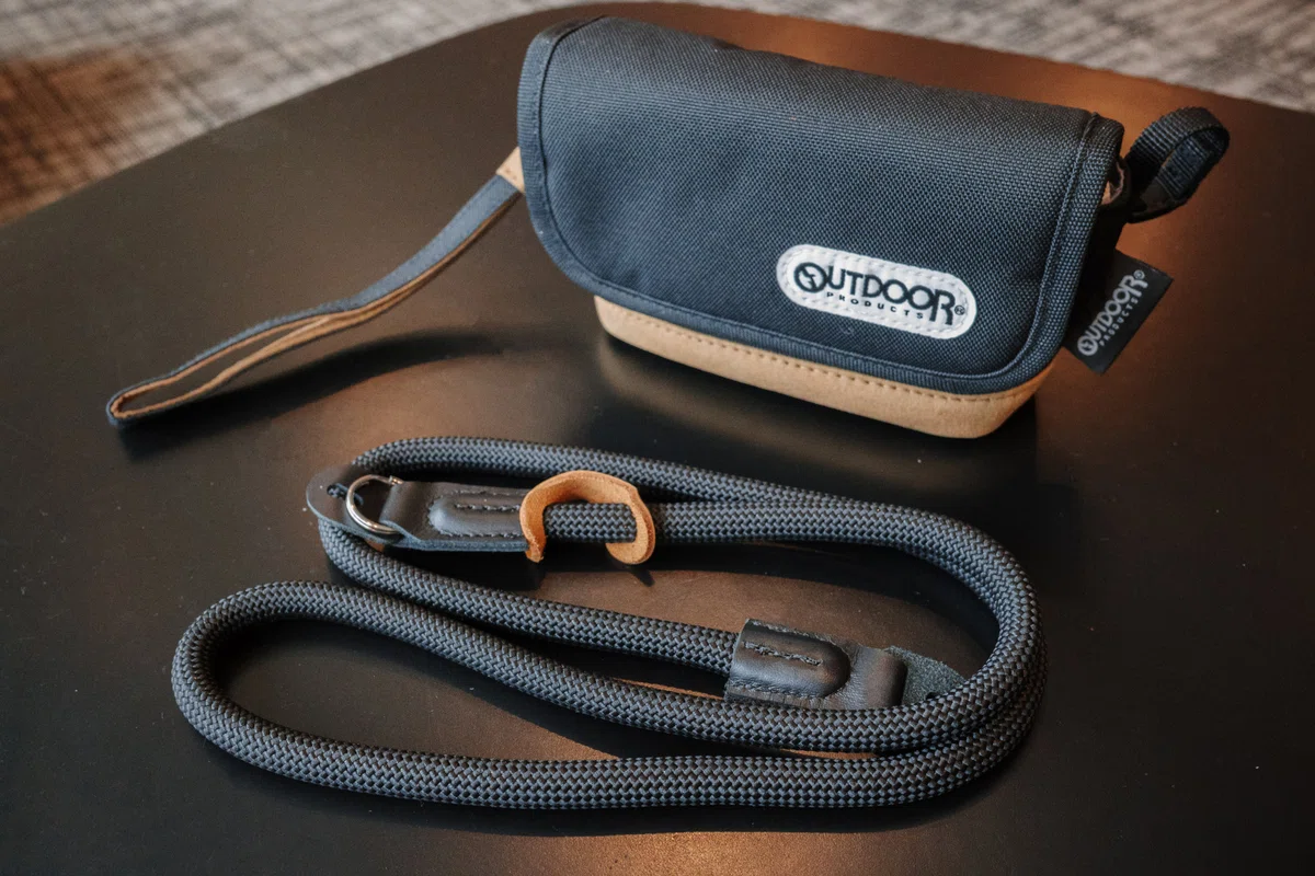 OUTDOOR PRODUCTS Camera Pouch 05 with a black K and F Concept neck strap