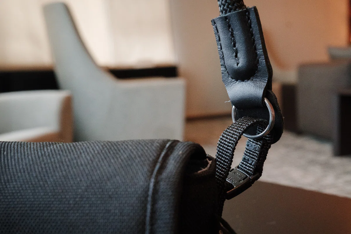 Camera neck strap attached to the removable buckle-shaped loop on the camera pouch