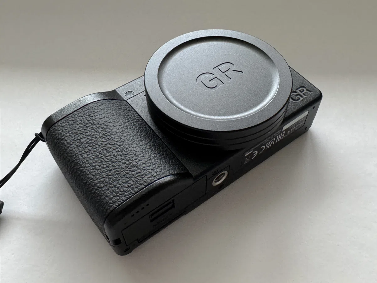Close-up of the metal lens cap on a Ricoh GR IV